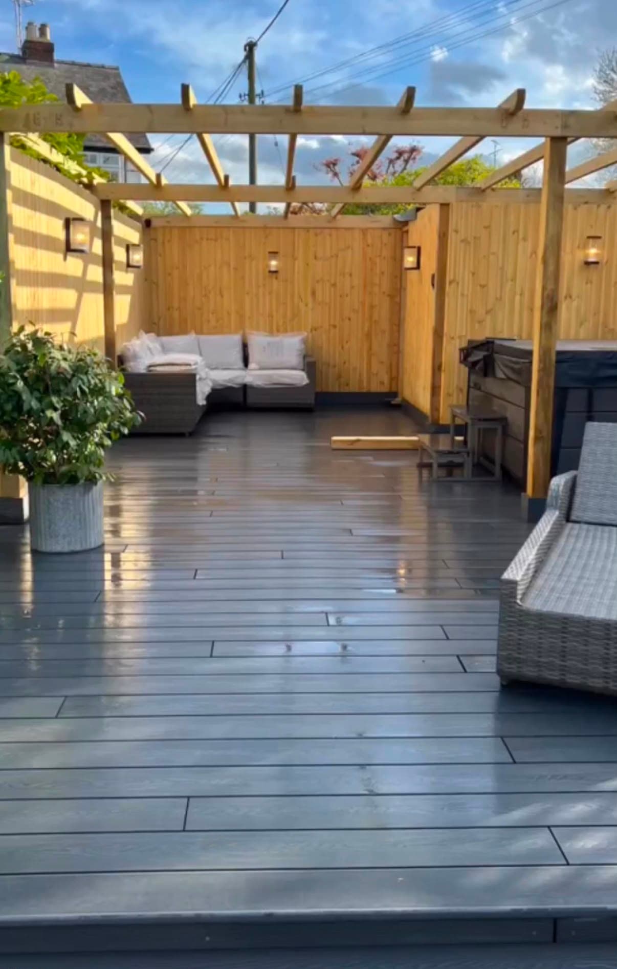 the finished shot — composite deck, pergola, lit fence, hot tub